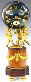 A 20th Century French table clock with three Cherubs holding a sphere aloft