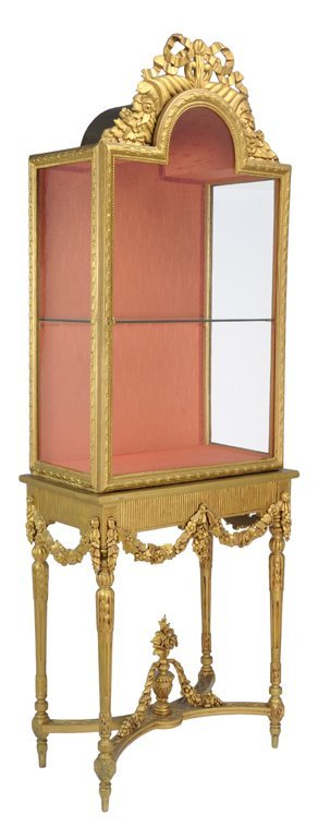 A Louis Xvi Style Giltwood Vitrine On Stand 19th C: A LOUIS XVI STYLE GILTWOOD VITRINE ON STAND 19th Century An exaggerated arched bonnet adorned with giltwood pierce carved ribbon and floral detail above a glass door. The body housing a glass shelf an