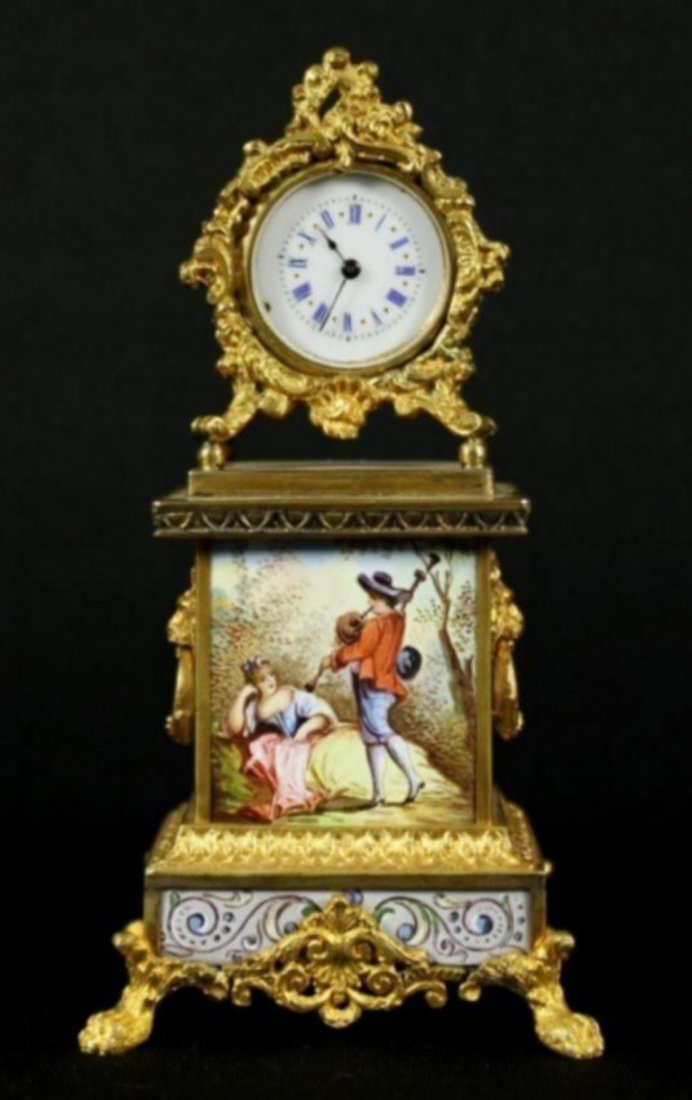 FRENCH ENAMEL ORMOLU CLOCK: A small windup clock with enamel dial and rococco frame, gold metal mounts and eight fine enamel panels including courting scenes with 18th century characters. Measures 4.75 x 2.5 inches.