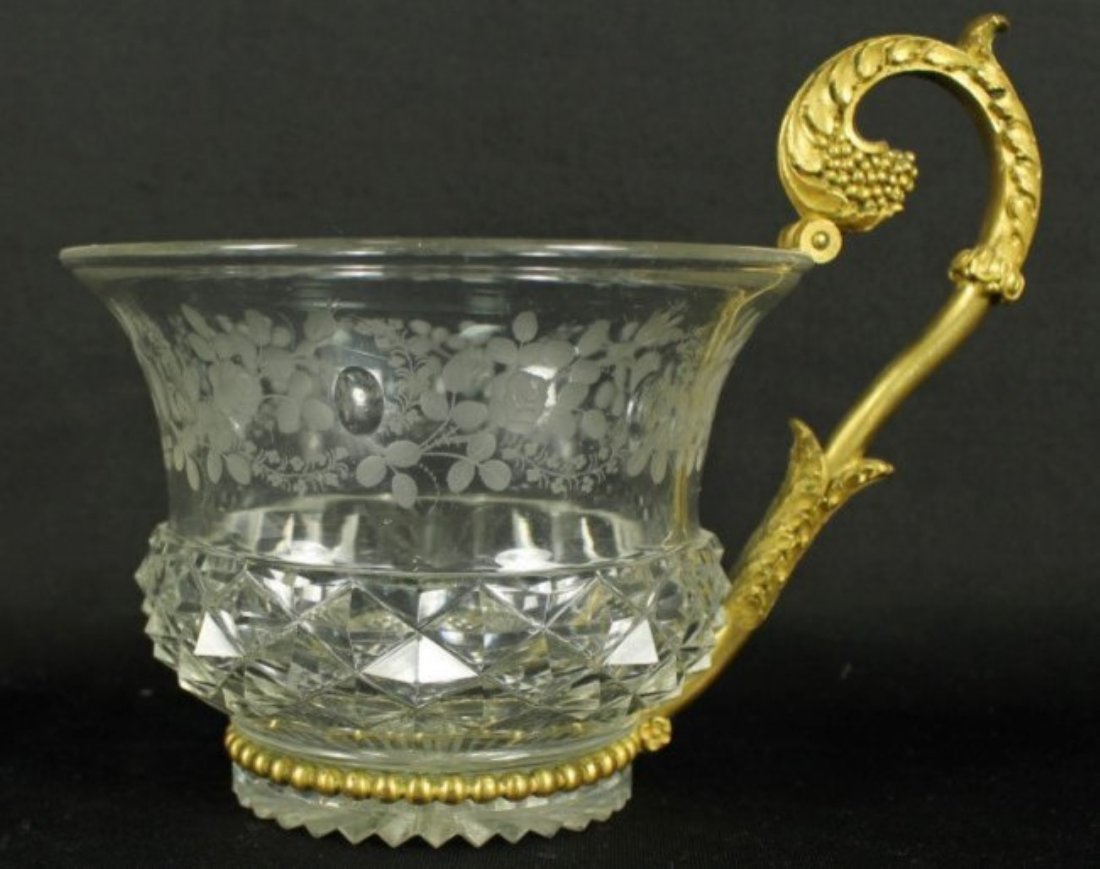 BACCARAT STYLE GILT BRONZE AND CUT GLASS CUP: BACCARAT STYLE GILT BRONZE AND CUT GLASS CUP. MEASURES H: 5 1/4" W: 6"