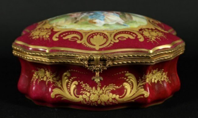 A Sevres Style Porcelain and Gilt Metal Mounted Box: A Sevres Style Porcelain and Gilt Metal Mounted Table Casket, of cartouche form, decorated with a courting couple, signed Dauchot, having Made in France interlaced Ls mark to base. Width 7 3/4 inches.