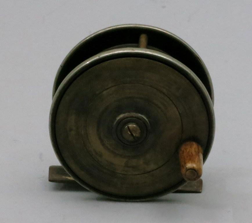 Unmarked English Brass Trout Reel: 2 3/4"dia. and 7/8" spool width. The reel has a brass crank plate and bone crank knob while the tail piece is hard rubber, no major dings and great patina. Reel is in Very Good condition.