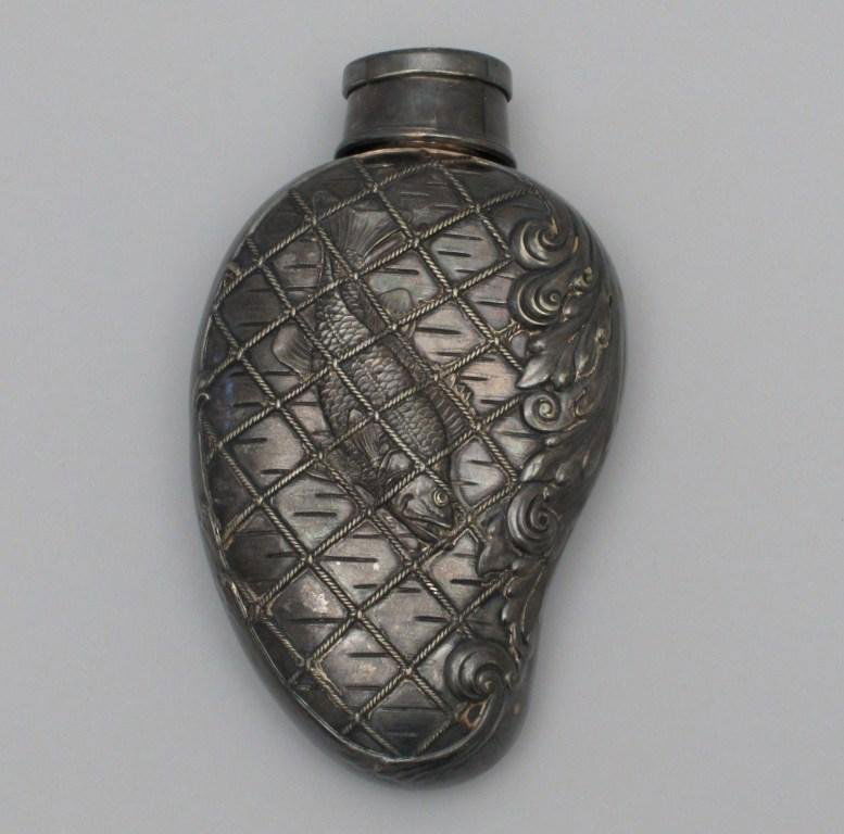 Attractive Silverplated Kidney Shaped Flask: Possessing intricate embossed net, fish and floral design, This 6 1/2" flask has a lid that expands into a small cup. In Excellent condition with old patina.
