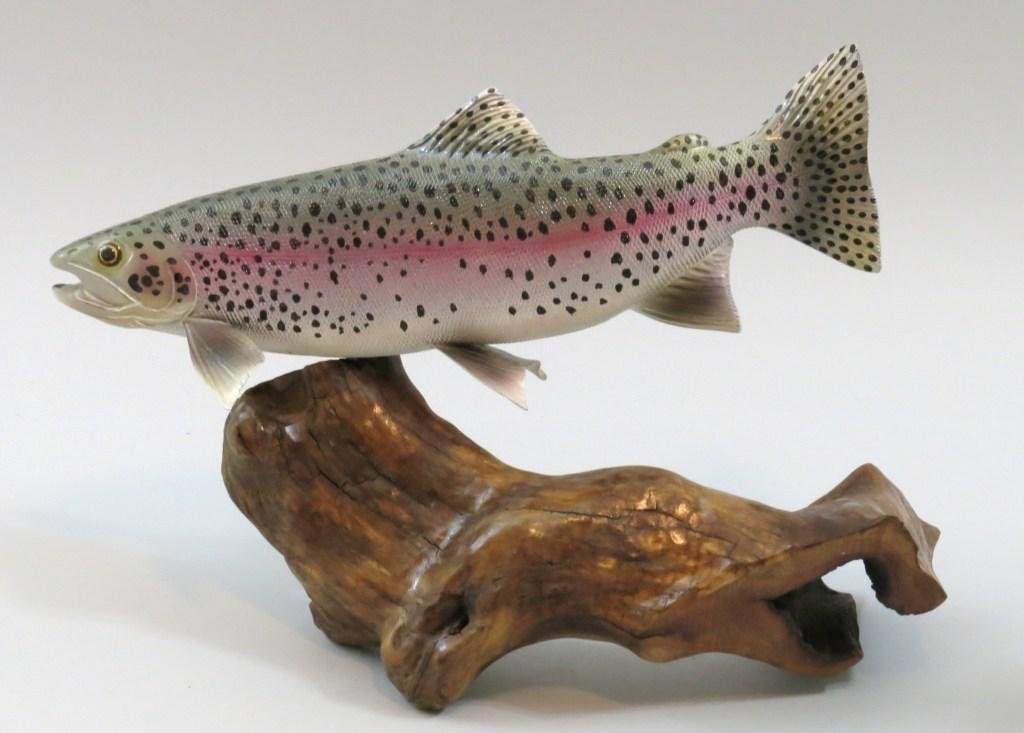 Large Tupelo Carving of a Rainbow Trout by Jim Wiley: Measuring 15" x 10" of a swimming rainbow trout on a driftwood base. Signed by the carver with his code "1222", carved in 2012 and the twenty-second carving of that year. This contemporary carver's st