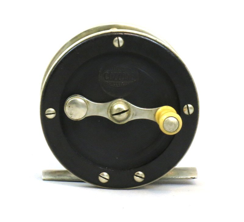 Cozzone German Silver & Hard Rubber 80 yd. Trout Reel: Small 80 yd. 2 3/8" dia. reel clearly marked "Cozzone" in oval logo on the face plate, back plate mounted wear compensating bearing cap, full length foot, strong click, crack free hard rubber end plat