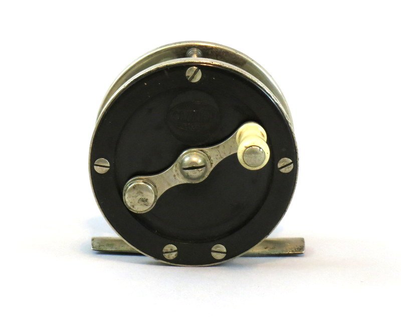 Cozzone German Silver and Hard Rubber Trout Reel: Small 60 yd. 2 1/4" dia. reel clearly marked "Cozzone" in oval logo on the face plate, back plate mounted wear compensating bearing cap, full length foot, crack free hard rubber end plates with some m