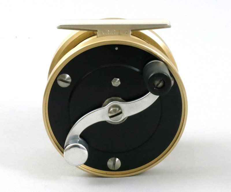 3 1/8" Stan Bogdan Size "0" Salmon Reel: Pale gold frame with black anodized side plates. Weight of 11 oz., recommended use with 9 wt. line and 150 yds. 20# backing, left hand wind, marked "No.0 LH" on foot, 3 1/8" diameter and 1 1/8" wide s