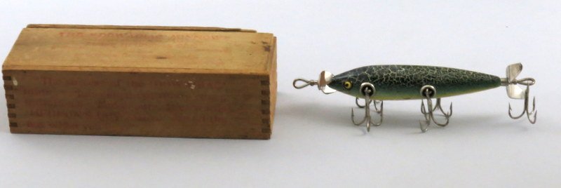 Heddon 150 Minnow in Wood Box: Green crackle back 5 hook minnow with red hand painted gill marks, long slender body with tapered nose, unmarked props, perfect glass eyes, cup rigged with clean shiny hardware. Condition is about Ver
