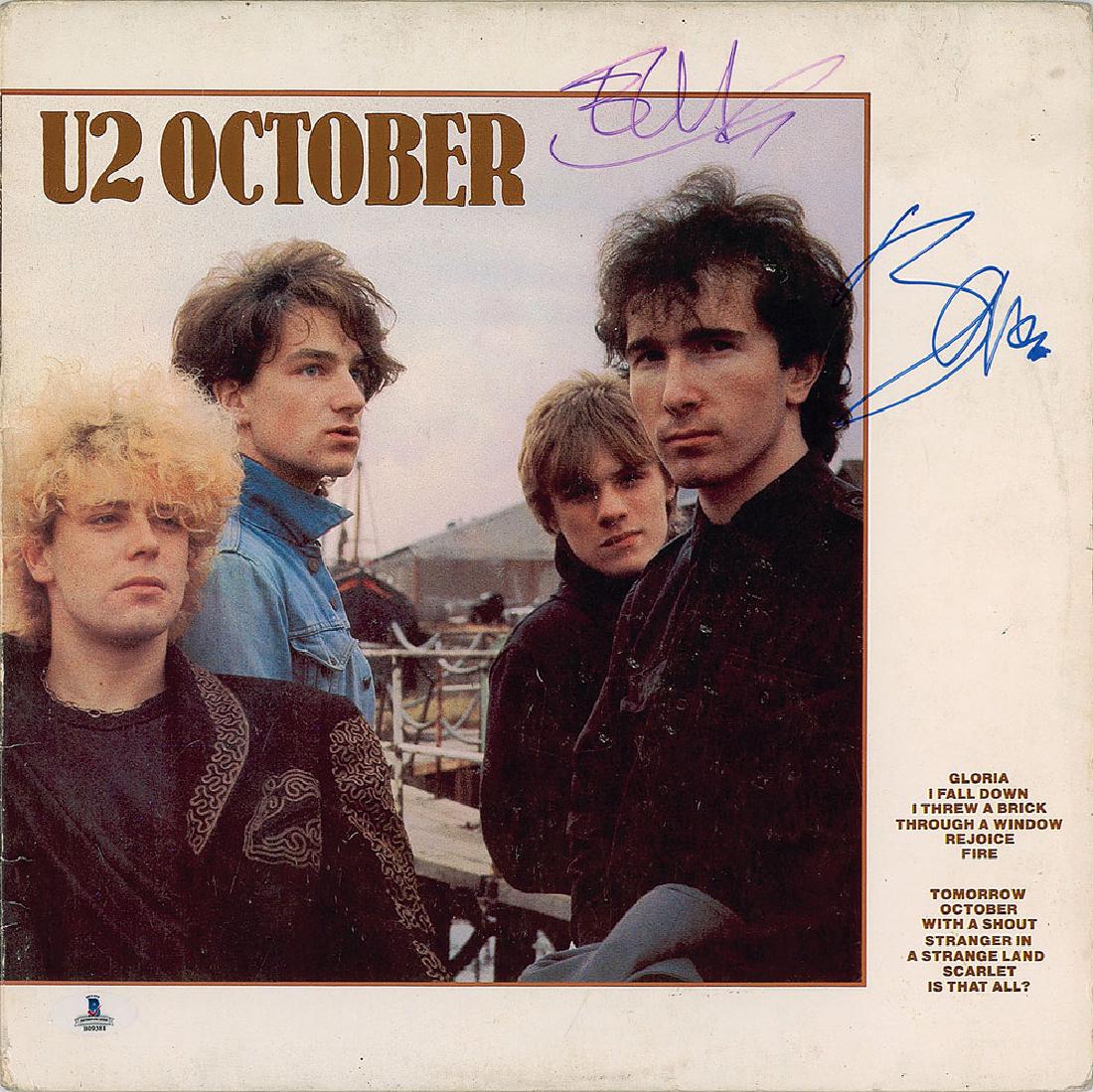 U2: Bono and Edge Signed Album: October album signed on the front cover in purple felt tip by Edge and in blue felt tip by Bono, with reverse of album signed by one other. In fine condition, with light soiling and a Beckett authenti