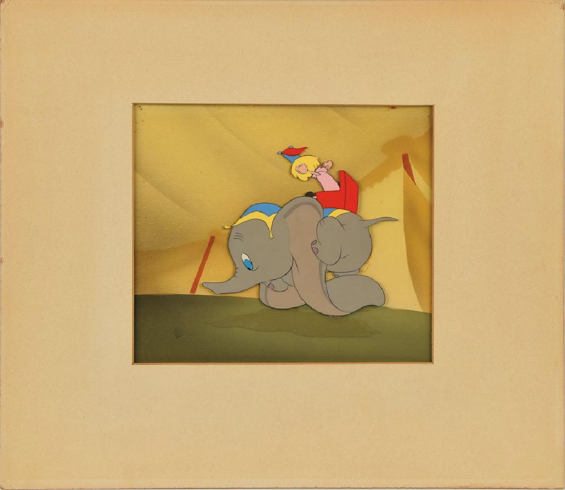 Dumbo production cel from Dumbo: (Walt Disney Studios, 1941) Original production cel featuring Dumbo from Dumbo, showing the young elephant tripping over his large ears with a small doll stationed on his back. The cel has been trimme