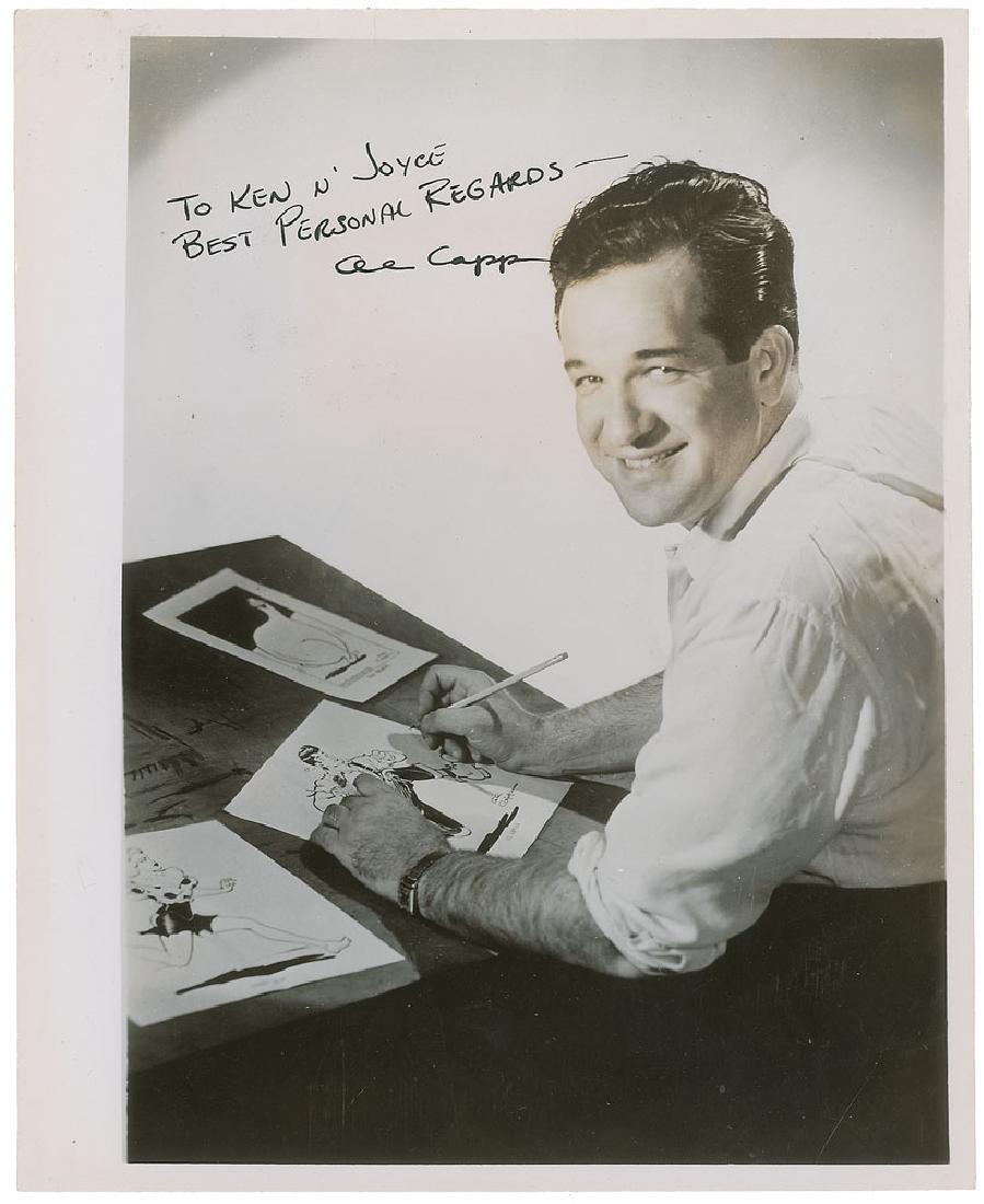 Al Capp: Wonderful glossy 8 x 10 photo of Capp seated at his sketching table, boldly signed and inscribed in fountain pen, "To Ken n' Joyce, Best Personal Regards—Al Capp.” A collector's label on the rever