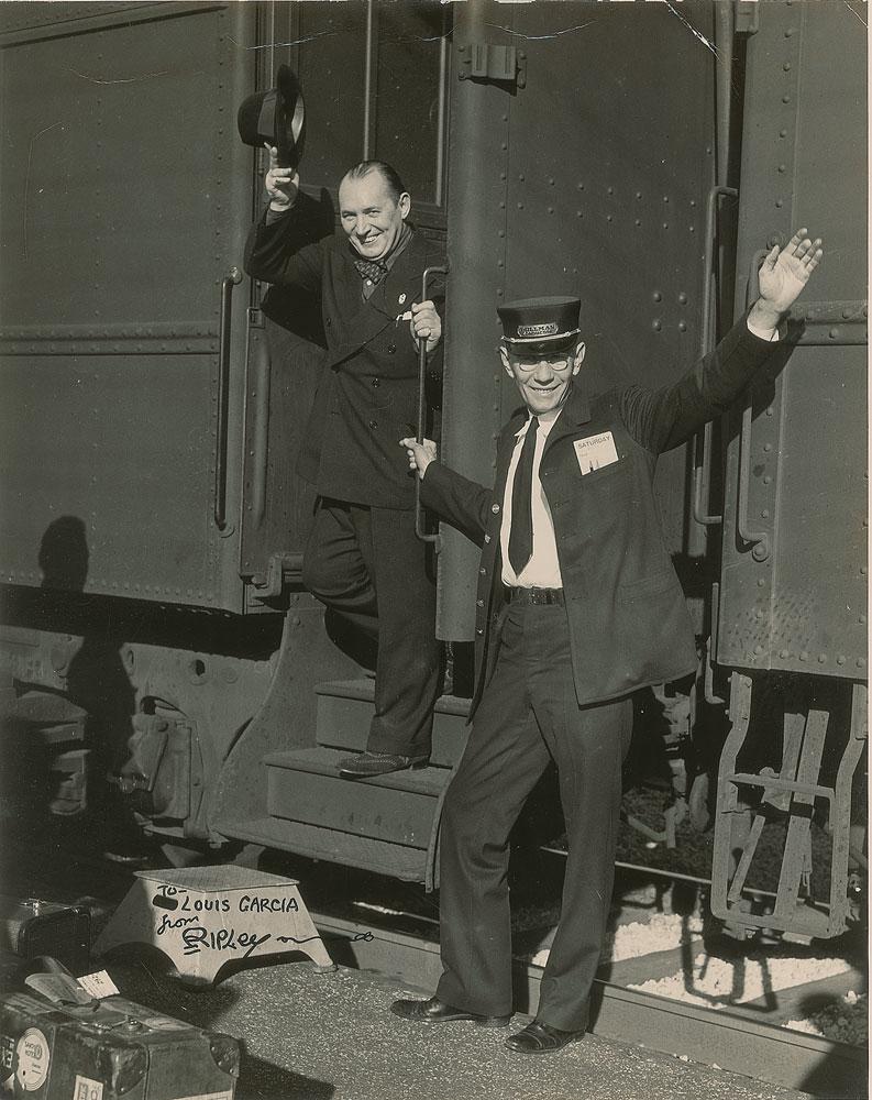 Robert Ripley: Vintage glossy 7.5 x 9.5 photo of Robert Ripley and a Pullman conductor waving from a train car, signed and inscribed in black ink, "To Louis Garcia, from Ripley." Reverse bears a Louis F. Garcia phot