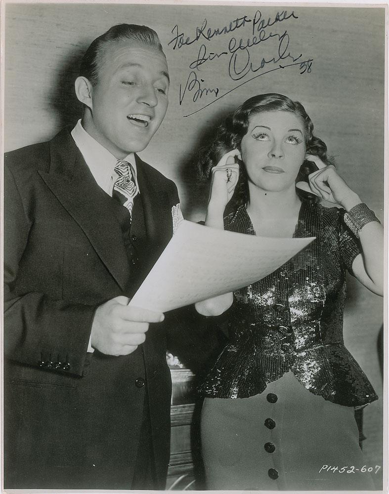 Bing Crosby: Two photos: a vintage glossy 7.25 x 9.25 photo of Crosby singing from sheet music, much to the chagrin of comic Martha Raye, signed and inscribed in fountain pen, "For Kenneth Parker, Sincerely, Bing
