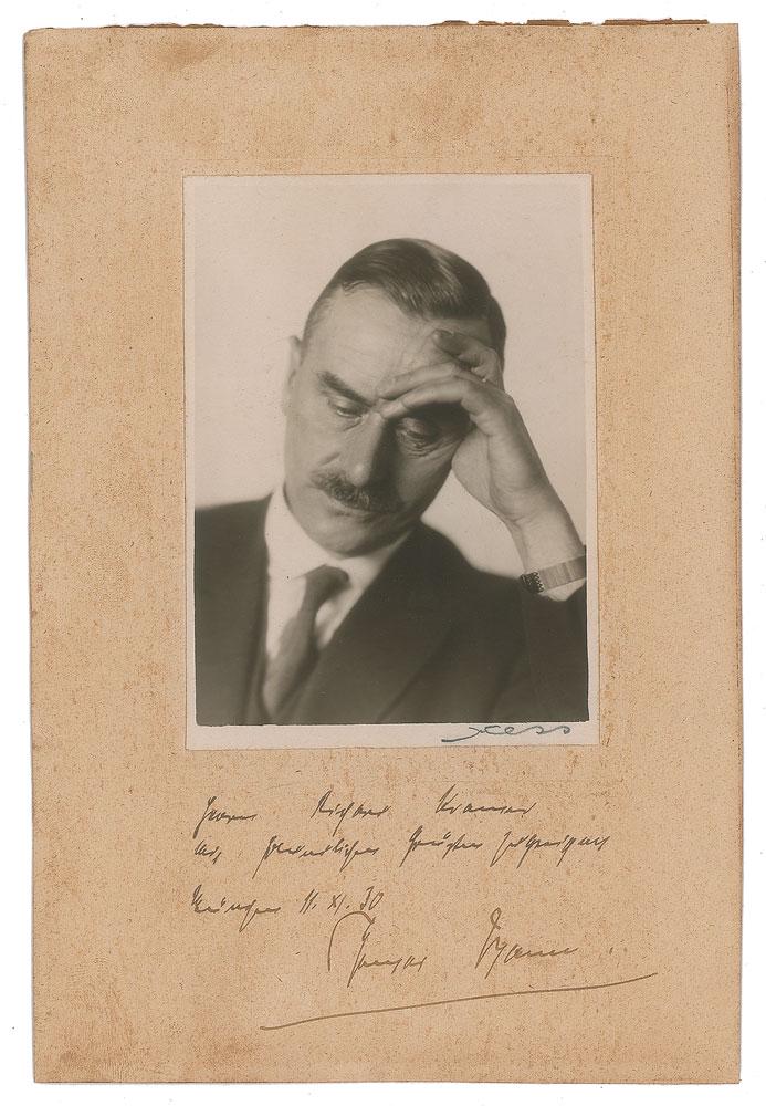 Thomas Mann Signed Photograph: Vintage matte-finish 3.25 x 4.5 portrait of Mann in a thoughtful pose, affixed to a 5.5 x 8.25 mount, signed and inscribed on the mount in fountain pen in German, and dated November 11, 1930. In very