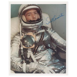 Scott Carpenter Signed Photograph: Color satin-finish 8 x 10 photo of Scott Carpenter relaxing in his silver space suit prior to his Mercury mission, signed in thin blue felt tip. In very fine condition.