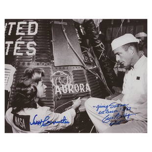 Scott Carpenter and Cece Bibby Signed Photograph: Satin-finish 10 x 8 photo of Mercury artist Cece Bibby talking to Scott Carpenter as she paints his Aurora 7 spacecraft, signed in blue felt tip, "Scott Carpenter" and "'Giving Scott an art lesson!