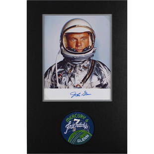 John Glenn Signed Photograph: Color satin-finish 8 x 10 photo of Glenn in his silver Project Mercury suit, signed in the lower border in blue felt tip. Double-matted with an embroidered Friendship 7 patch to an overall size of