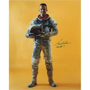 Gordon Cooper Signed Photograph: Color satin-finish 8 x 10 full-length photo of Cooper, with helmet in hand, posing in his Mercury space suit against a yellow background, signed in thin black felt tip, "Gordon Cooper, Faith 7." In
