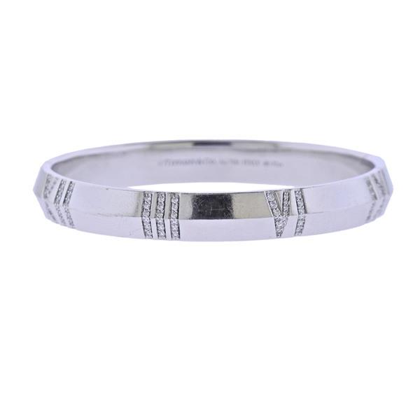 Tiffany & Co X Closed Narrow Hinged Gold Bangle: METAL: 18k Gold. GEMSTONES: Diamonds approx. 0.52ctw. MEASUREMENTS: Bracelet will fit 6" wrist and is 8mm wide. MARKED: Tiffany & Co au750 Italy d0.52ct. WEIGHT: 36.5 grams. Retail $13000. Co