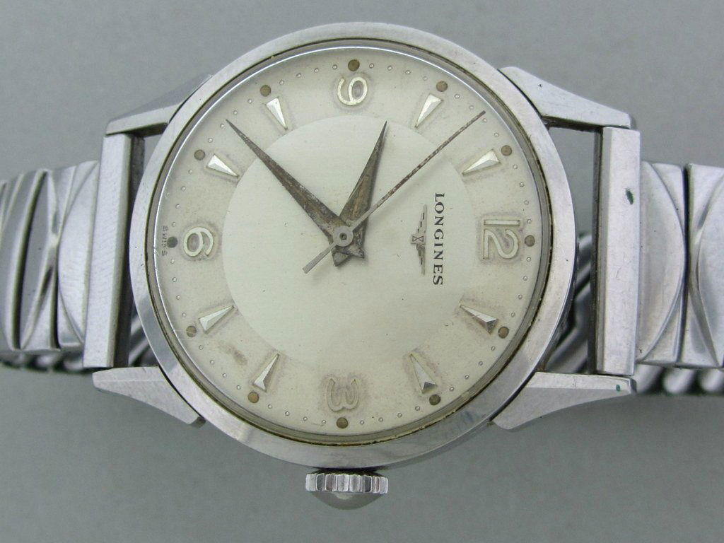 Men's Vintage 1950s Longines Steel Watch: Steel Screw back Case with Fancy Lugs 33mm without crown X 40mm lug tip to lug tip.Original 2tone dial with applied markers. Center second hand.