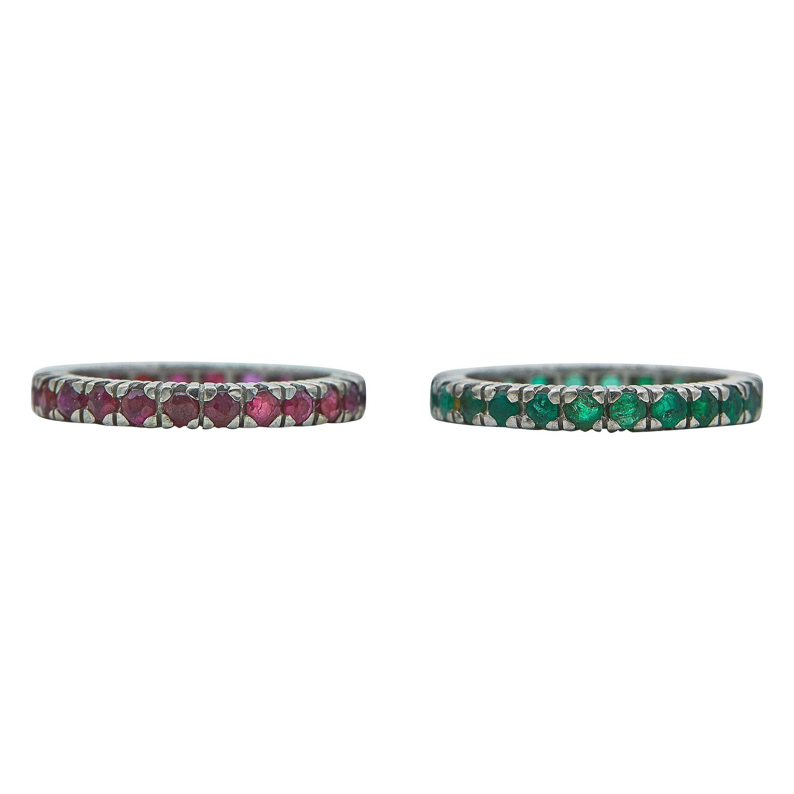 A Set of Two Platinum, Ruby, and Emerald Eternity Bands: METAL: Platinum; GEMSTONES: Ruby, Emerald; TESTED: Platinum; CONDITION: Pre-owned, Good; ITEM WEIGHT (GRAMS): 6.5 g; MEASUREMENTS: Both rings size 6 1/4