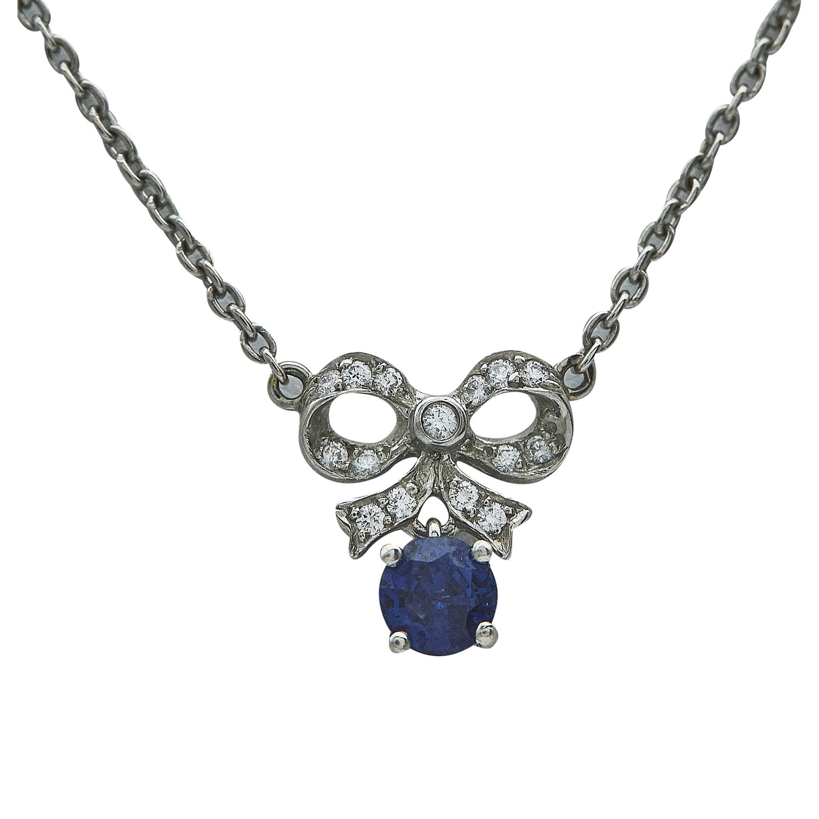 Platinum Diamond And Sapphire Bow Pendant Necklace With Diamond Station Chain: METAL: Platinum; APPROXIMATE TOTAL DIAMOND WEIGHT: 0.25 ctw; GEMSTONES: Sapphire weighing approx. 0.31 carats; STAMPED: PY950, TF; CONDITION: Pre-owned, Good; ITEM WEIGHT (GRAMS): 6 g; MEASUREMENTS: N