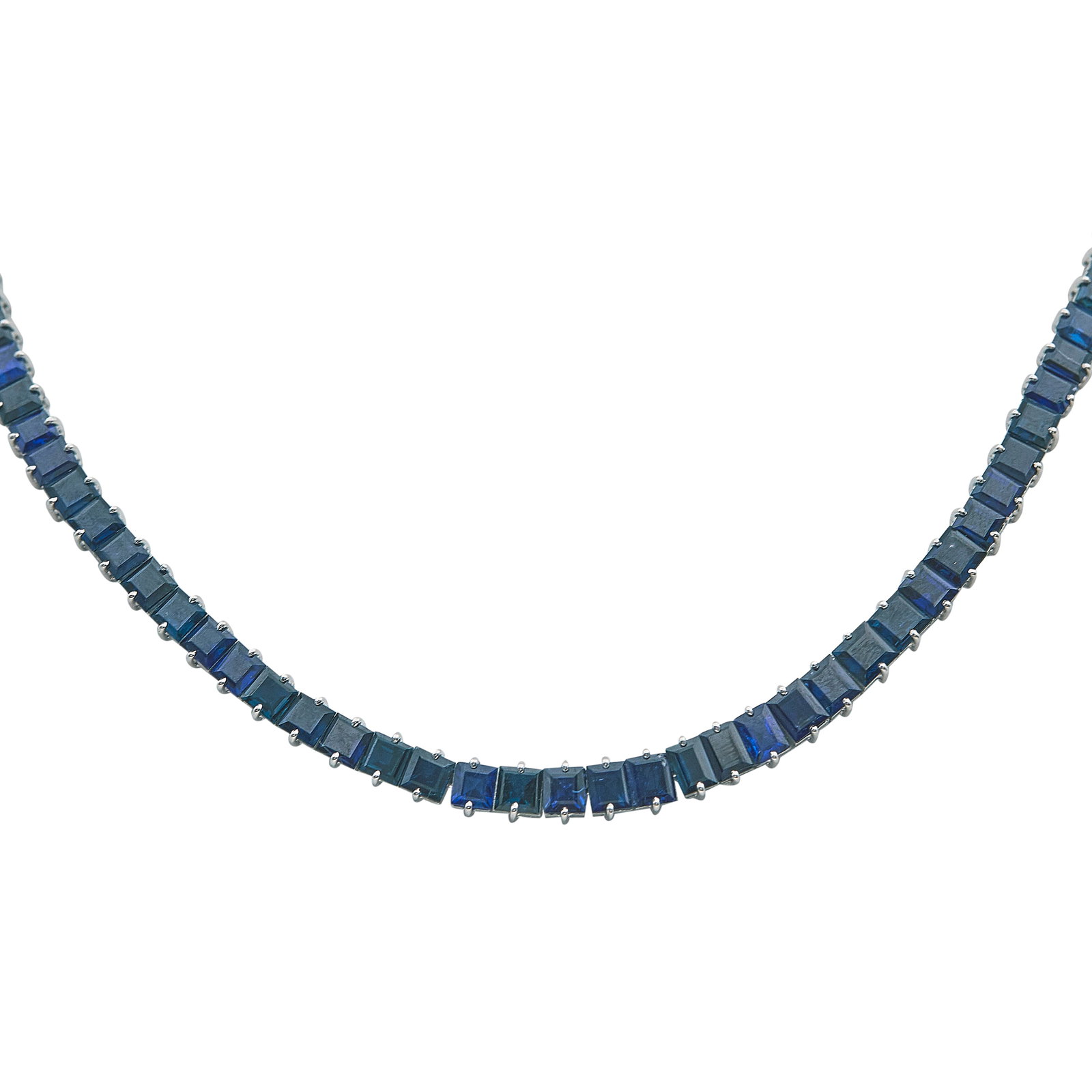 10K White Gold and Step Cut Sapphire Tennis Necklace: METAL: 10K White Gold; GEMSTONES: Sapphire; TESTED: 10K White Gold; CONDITION: Pre-owned, Very Good; ITEM WEIGHT (GRAMS): 41.7 g; MEASUREMENTS: Necklace 17 1/2 inches long