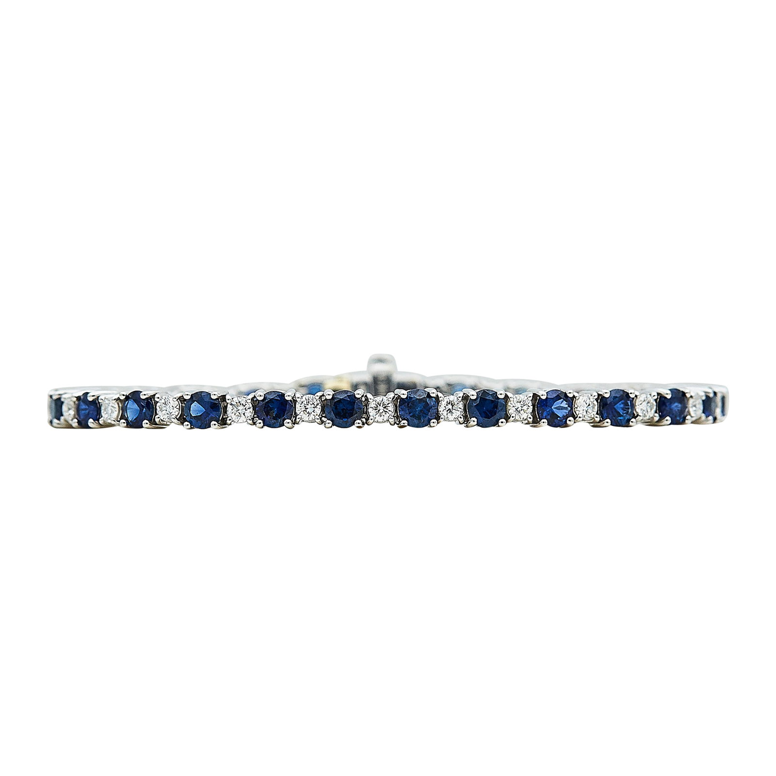 18K White Gold, Blue Sapphire, and Diamond Tennis Bracelet: METAL: 18K White Gold; APPROXIMATE TOTAL DIAMOND WEIGHT: 1 ctw; GEMSTONES: Sapphire; STAMPED: 750, BIRKS; CONDITION: Pre-owned, Very Good; ITEM WEIGHT (GRAMS): 11 g; MEASUREMENTS: Bracelet 6 1/8 inche