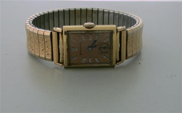 Bulova Mens President E 7AK Watch: BulovaPresident E21 JewelsSigned 4 timesAutomatic movementPush pull crownDial: PinkSeconds @ 6 o'clockGlass Crystal14k Gold caseGender/Size: Mens Rectangular Case: 21 mm x 28 mm No Box / No Papers