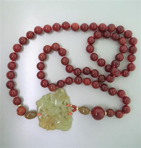 Carved Jade Carnelian Bead Necklace: Necklace is 42" long. Carnelian beads - 12mm to 20mm in diameter. Carved jade - 63mm x 50mm. Gold spacers. weight - 219.7g