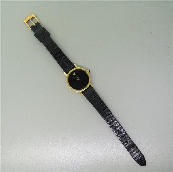 Movado 14k Gold Ladies Watch: 14k gold case - 24mm in diameter. Quartz movement - running order. Black dial, center hour & minute hands.