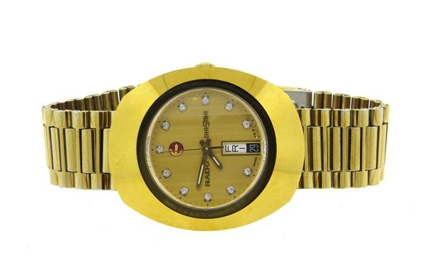 Rado Diastar Gold Tone Day Date Diamond Watch: Oval gold tone case - 35mm excl crown x 41mm, Automatic - running order. Gold tone dial with diamond markers, day & date at 6 o'clock, center second hand. Original band and buckle.Watches are