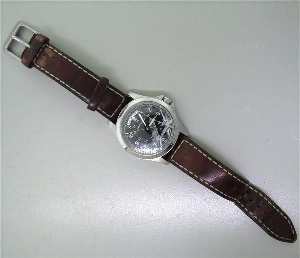 Hamilton Khaki Automatic Day Date Watch: Case - 40mm in diameter and 49mm lug tip to lug tip. Black dial with arabic numeral markers, center second hand, day date at 12 o'clock. Automatic - running order. Crystal is broken, needs replace