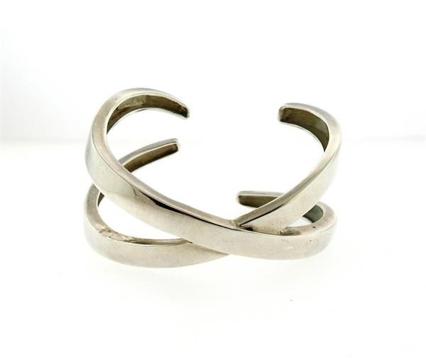 Tiffany & Co. Paloma Picasso Sterling Silver X Cuff: Sterling silver cuff measures 26mm at widest points. Will fit up to 5.5" wirst. Marked Tiffany & Co., Paloma Picasso, 925. Weight - 30.8 grams. Comes with Tiffany pouch. Gemstones have not be