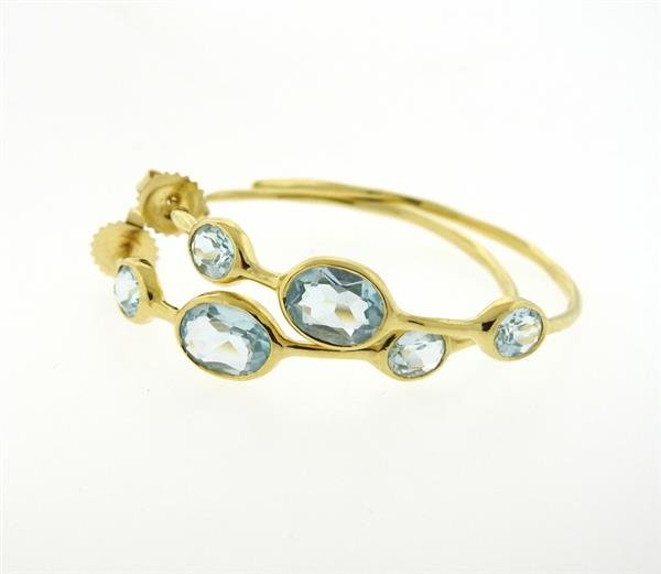 Ippolita Gelato 18K Gold Blue Topaz Hoop Earrings: 18K gold earrings feature blue topaz stations. Hoops measure 40mm in diameter, 8.2mm at widest points. Marked Ippolita, 18K. Weight - 8.2 grams. Gemstones have not been graded for color and clarity ,a