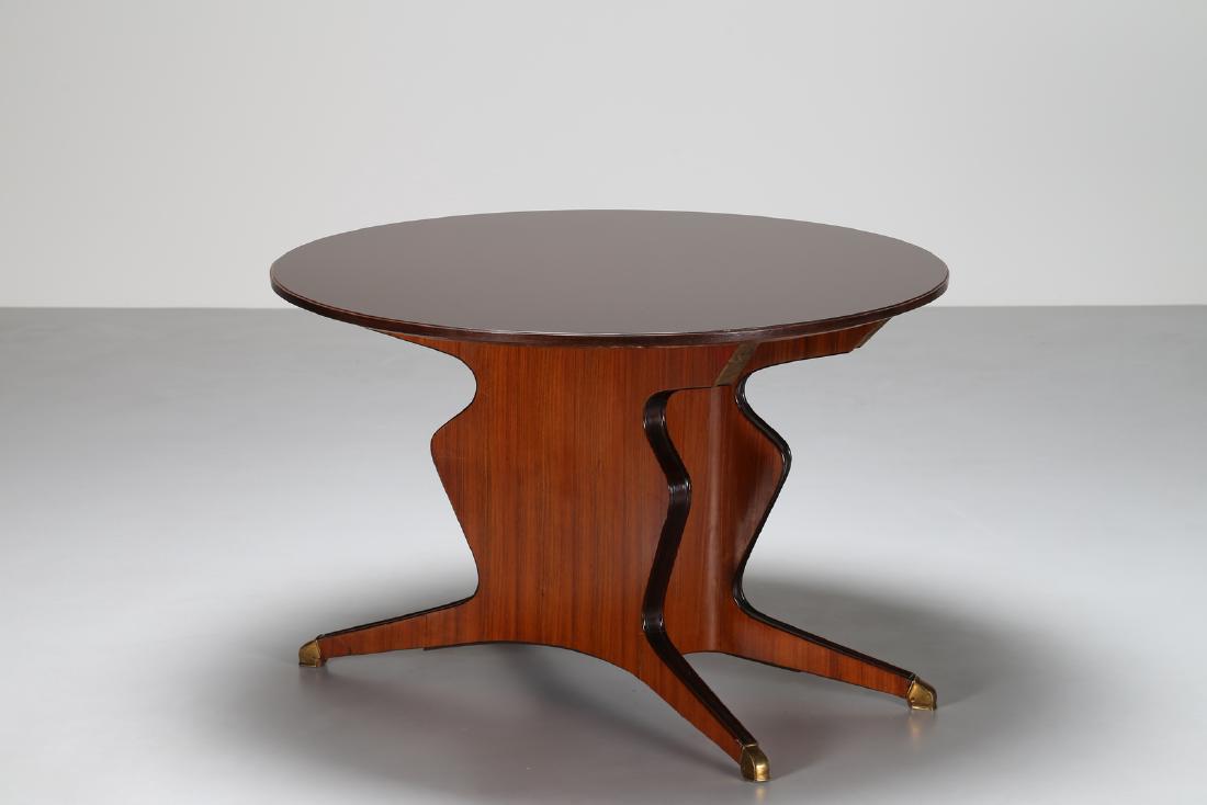 OSVALDO BORSANI Tavolo in palissandro e dettagli in: BORSANI OSVALDO (1911 - 1985) Tavolo in palissandro e dettagli in ottone, versione tondo, anni 50. . Cm 120,00 x 80,00. . Cornice presente