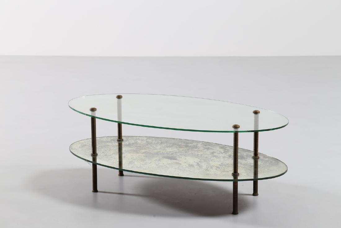 MANIFATTURA ITALIANA Oval coffee table.: ITALIAN MANUFACTURE Oval coffee table. Brass and glass. Cm 110,00 x 56,50 x 42,00. Brass legs, glass lowered top, mirror top, 40s.