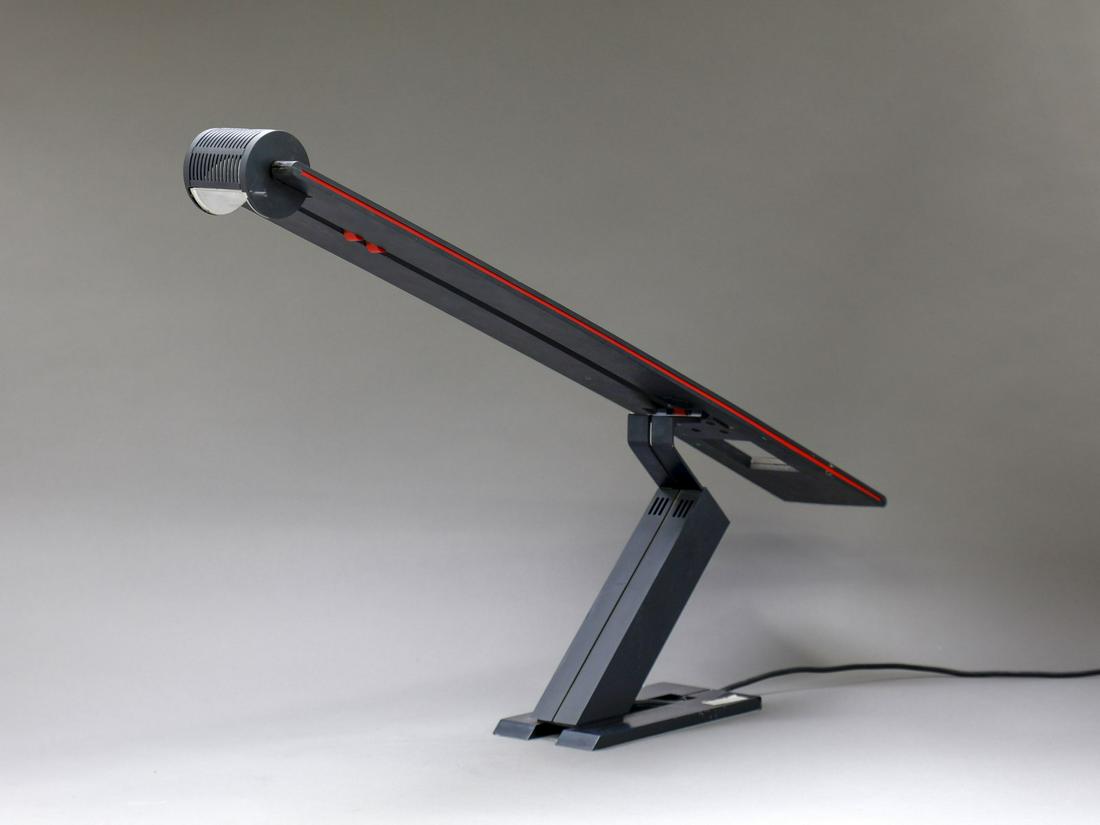 MARIO BOTTA Melanos table lamp, Artemide production,: Melanos table lamp, Artemide production, 70s. Plastic and painted metal material.. Cm 85,00 x 27,00 x 11,00. 1868
