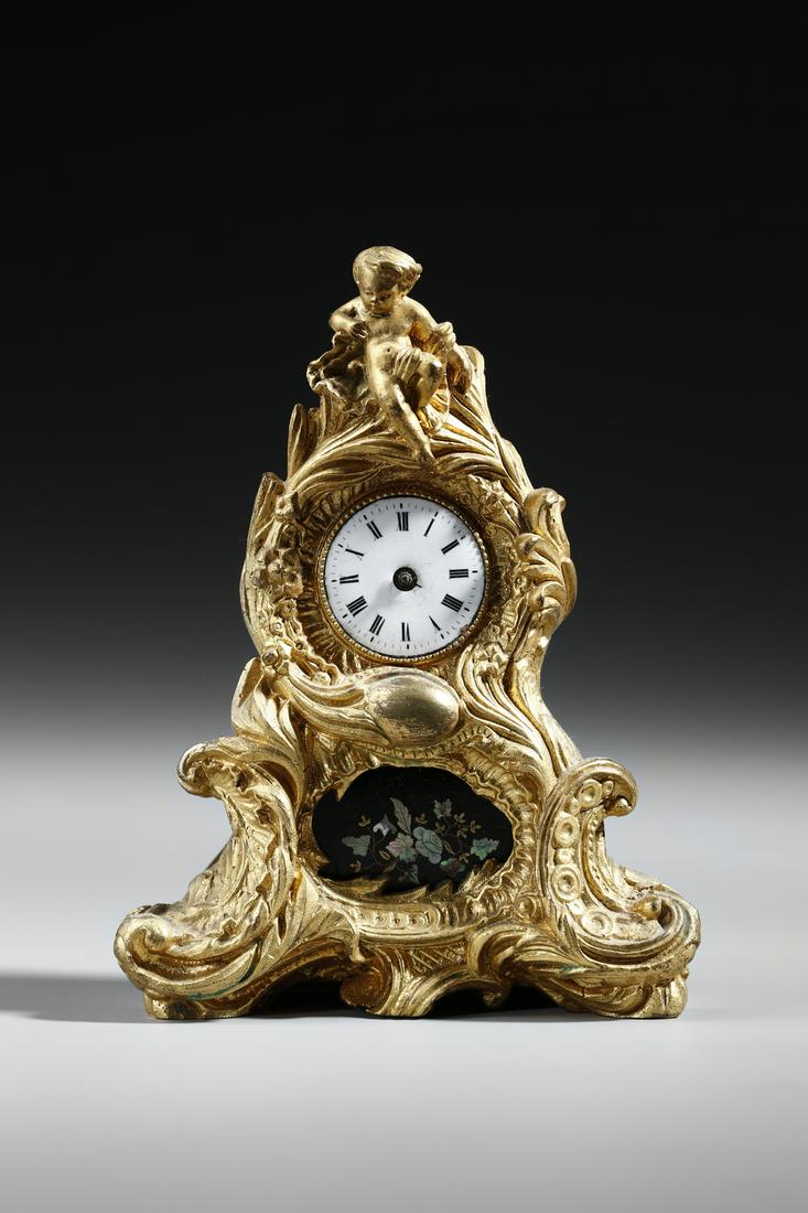 MANIFATTURA FRANCESE DEL XIX SECOLO A small Louis XV style gilt bronze table clock, decorated with (1 of 6)
