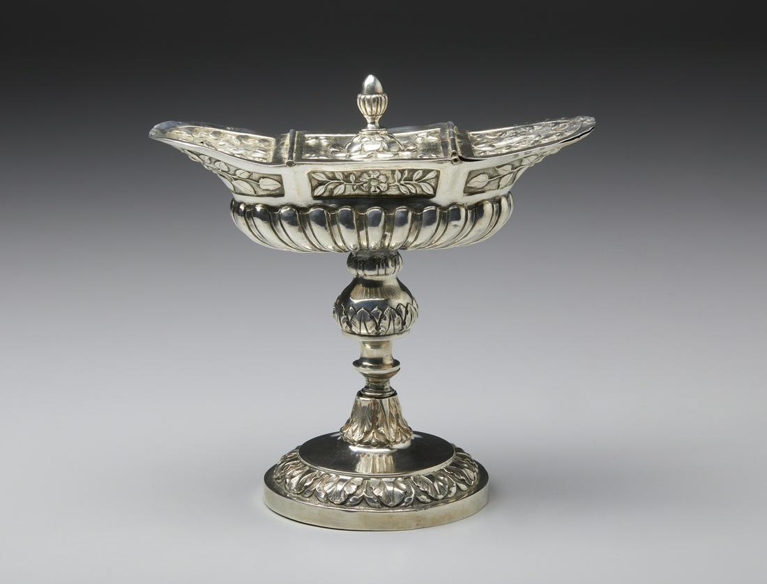 ARGENTIERE LOMBARDO DEL XIX SECOLO A silver incense holder navicella with phytomorphic and: A silver incense holder navicella with phytomorphic and 'baccellate' decorations, resting on a circular foot. . Cm 20,50 x 20,50 x 10,50. Milan guarantee office mark (Globe with the Zodiac) and silver