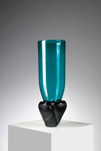 LAURA DE SANTILLANA Vase form the Munchen series for Venini, Murano.: DE SANTILLANA LAURA (1955 - 2019) Vase form the Munchen series for Venini, Murano. 1984. Upper part in blue transparent blown glass and base in dark blue solid glass with battuto surface.. Cm 17,00 x