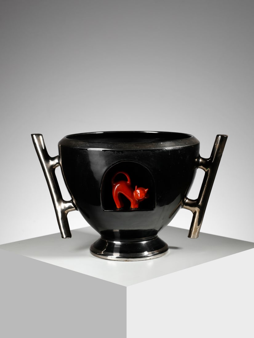 MANIFATTURA DI DERUTA Cista with handles and relief decoration of a cat inside a niche.: MANIFATTURA DI DERUTA Cista with handles and relief decoration of a cat inside a niche. Black, red and silver glazed ceramic.. Cm 39,00 x 24,00 x 32,00. 1930s.Signed under the base.