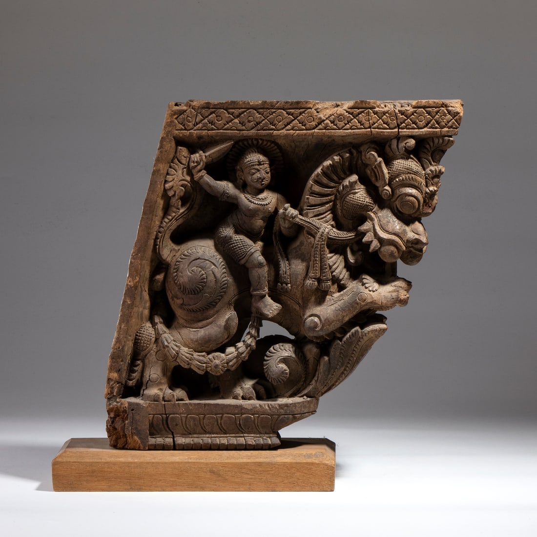 WOODEN SCULPTURE DEPICTING AN INDIAN DEITY RIDING A MYTHICAL FIGURE.India, 18th century. (1 of 4)