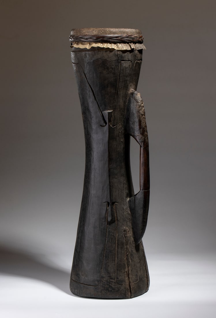 ASMAT CEREMONIAL DRUM IN WOOD, REPTILE SKIN, AND RATTAN.Papua New Guinea, Early 20th century. (1 of 3)