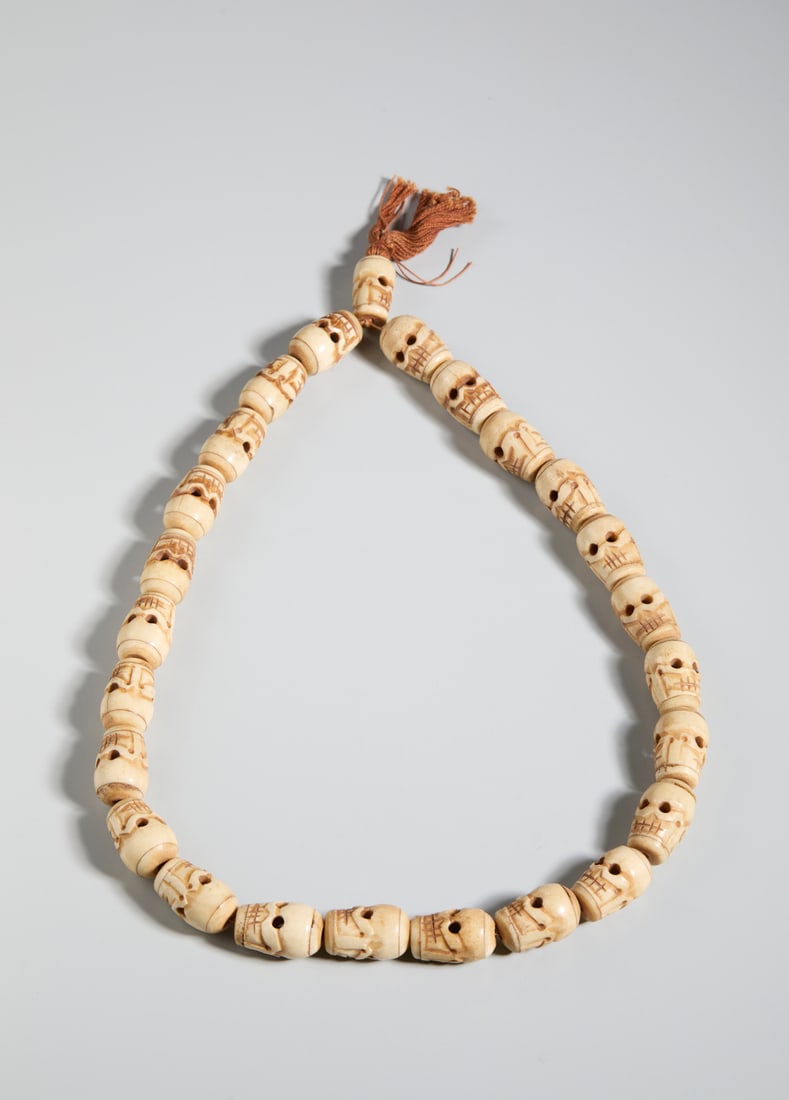 NECKLACE WITH HAND-CARVED YAK BONE SKULLS.Nepal, 20th century. (1 of 3)