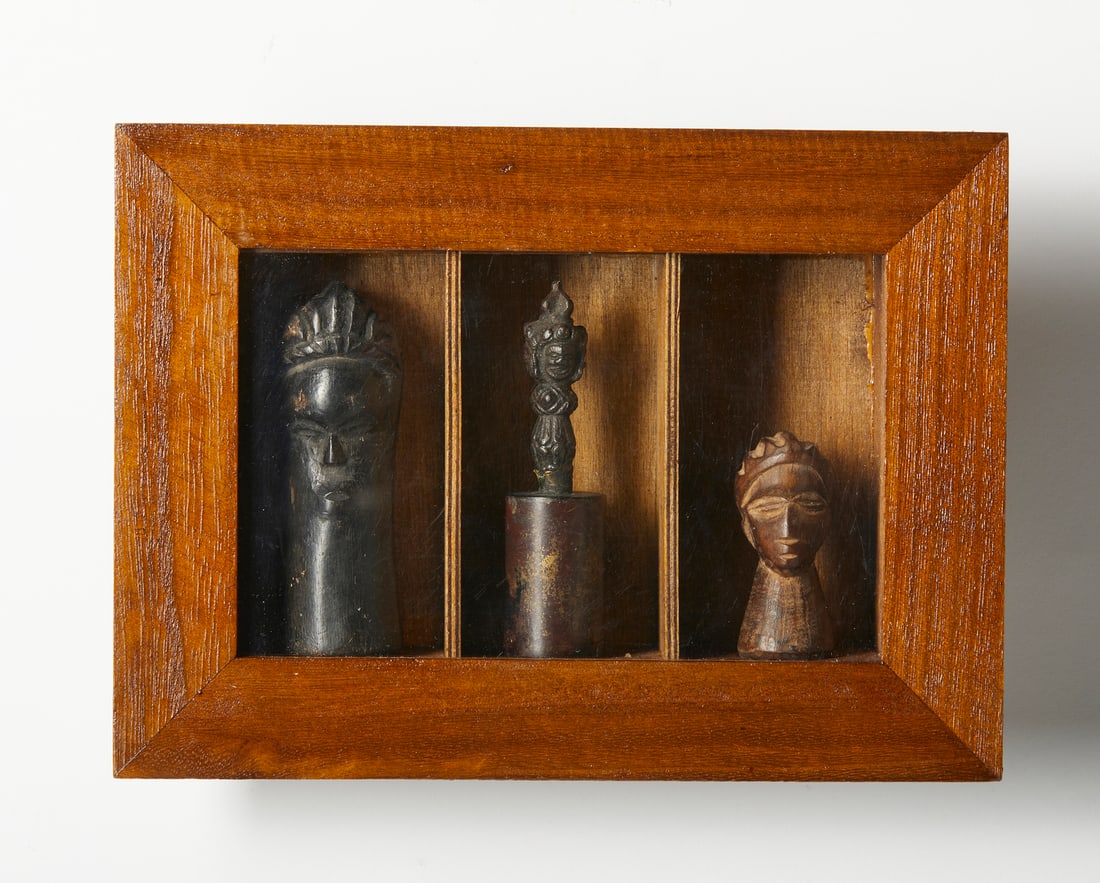 SMALL SHRINE WITH TWO AFRICAN HEADS AND A TIBETAN AMULET. Late 19th century. (1 of 3)