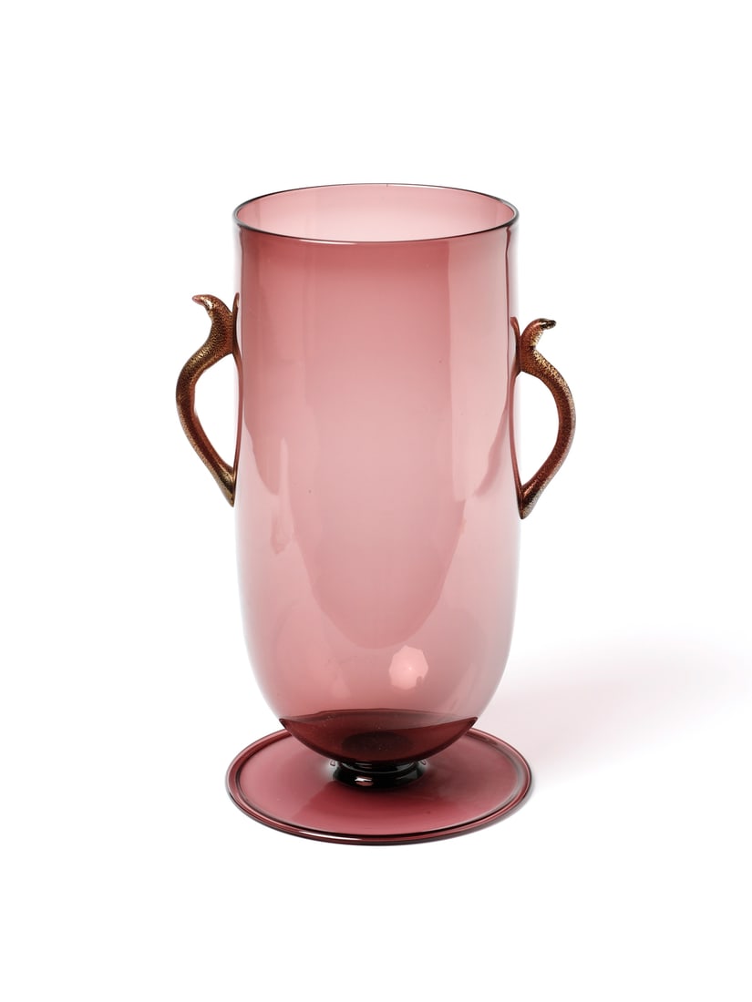 M.V.M. CAPPELLIN Two-handled vase with disc base, Murano.: M.V.M. CAPPELLIN Two-handled vase with disc base, Murano. Clear amethyst glass; handles with gold leaf application.. Cm 16,00 x 30,50 x 16,00. 1920s.Signed "MVM Cappellin Murano" under the base.