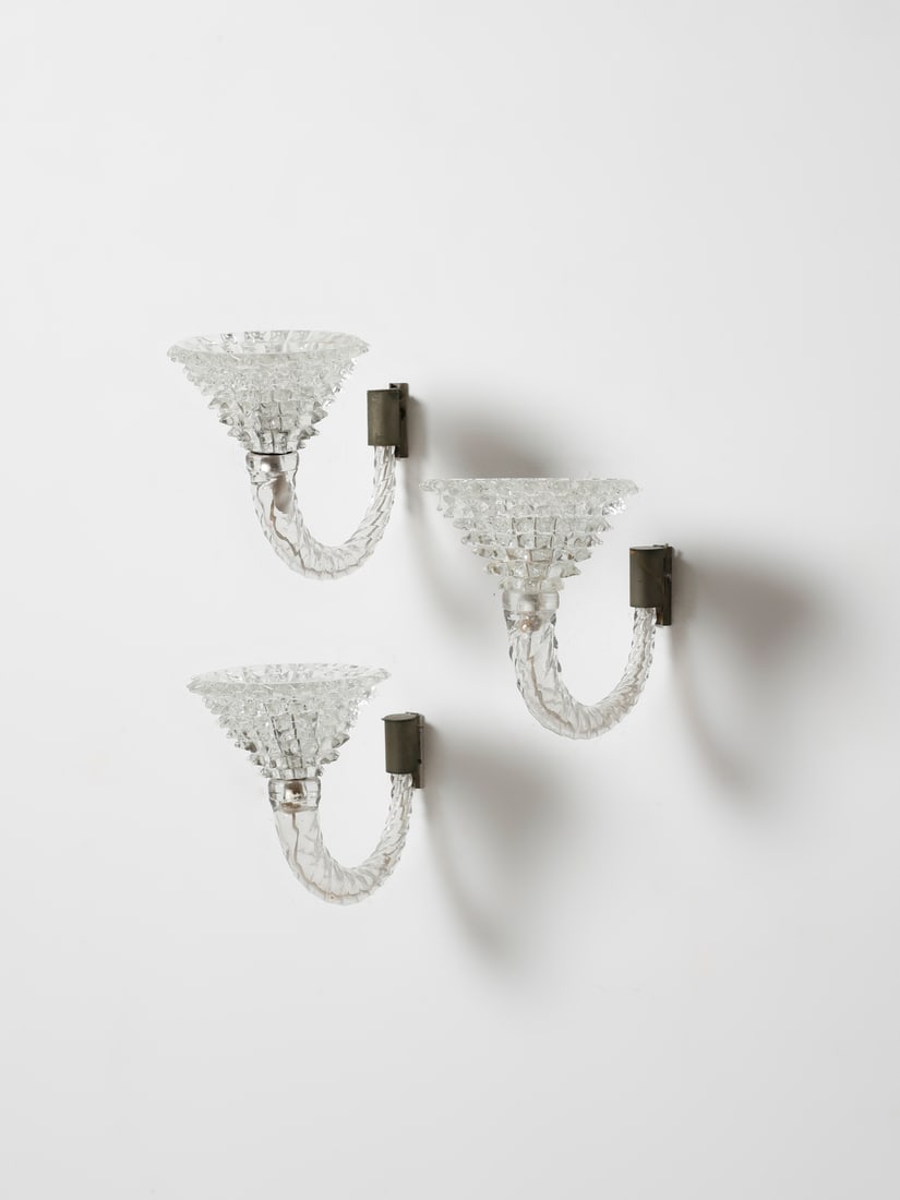 ERCOLE BAROVIER Three wall lamps, Barovier & Toso manufacture, Murano.: BAROVIER ERCOLE (1889 - 1974) Three wall lamps, Barovier & Toso manufacture, Murano. 1938. Crystal glass with cups decorated with rostri, stem decorated with torchon; brass structure.. Cm 36,00 x 25,0