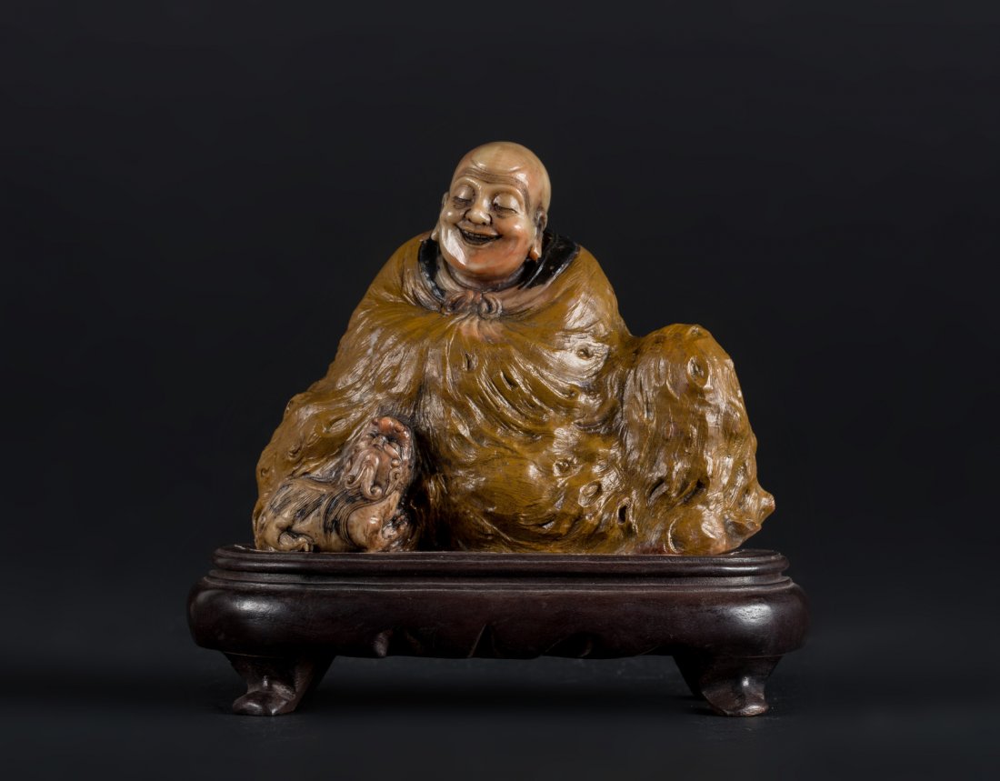 Arte Cinese A soapstone carving of a Lohan on a wooden: A soapstone carving of a Lohan on a wooden stand China, Qing dynasty, 19th century . . Cm 13,50 x 11,00.