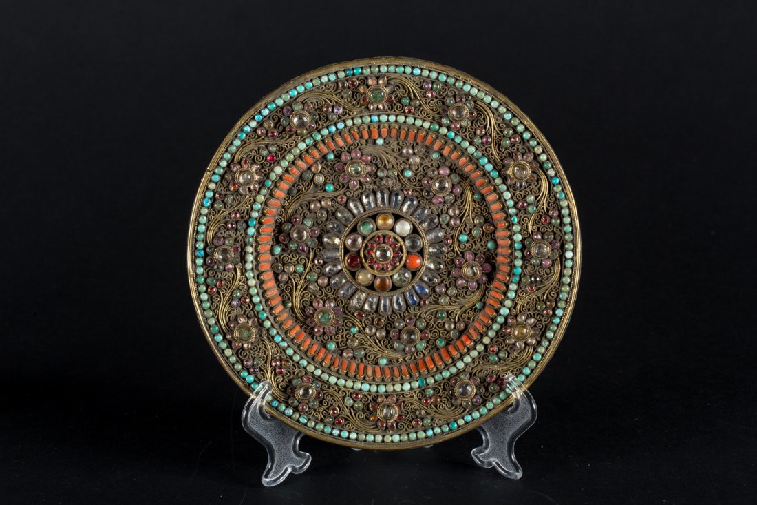 Arte Himalayana A silver and silver gilt temple dish: A silver and silver gilt temple dish encrusted with semi-precious stones Nepal, Rana period, 19th century . . Cm 21,30. Precious decorative plate, richly adorned with filigree shoots and flowers set w